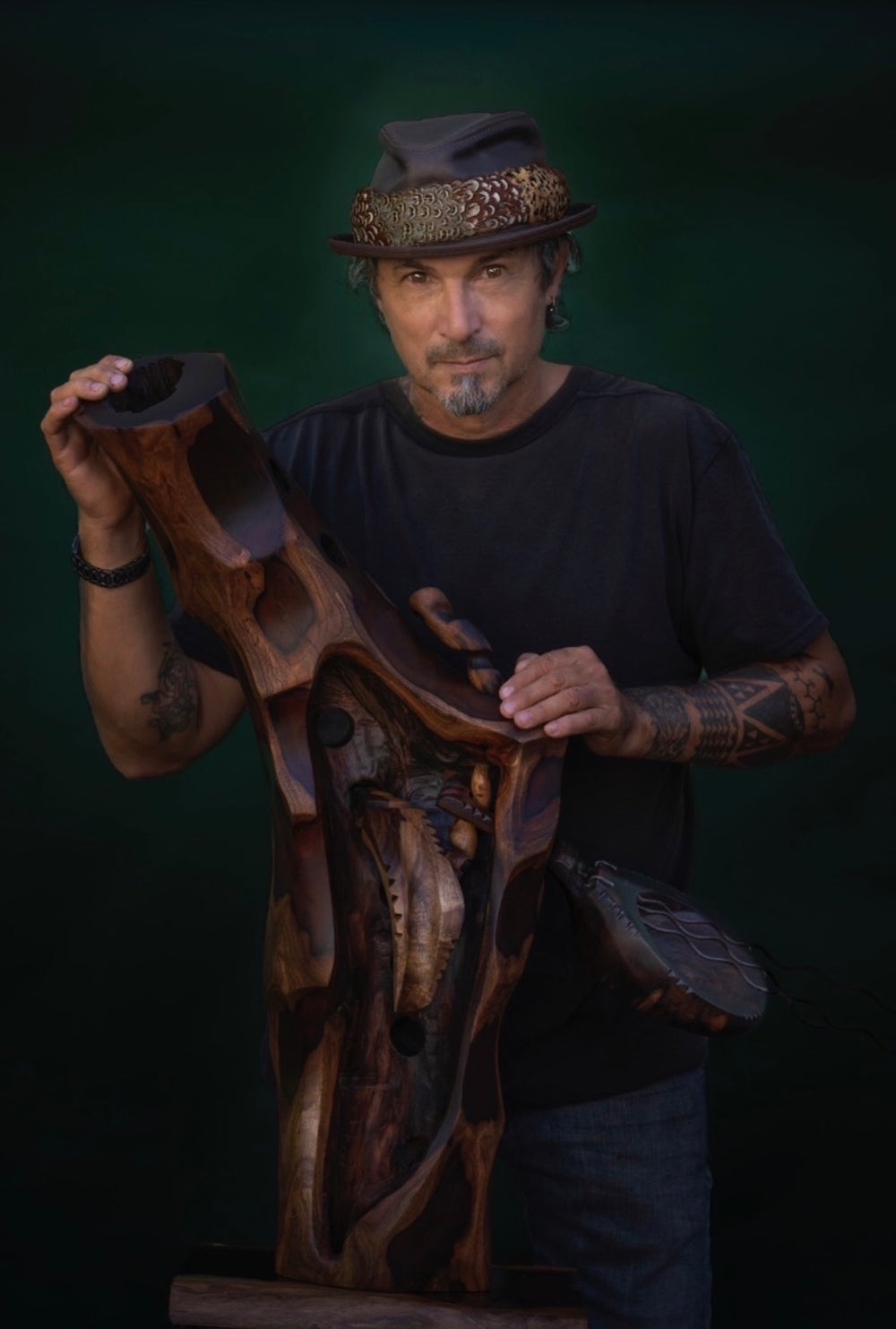 Avi Molinas portrait with sculpture and hat