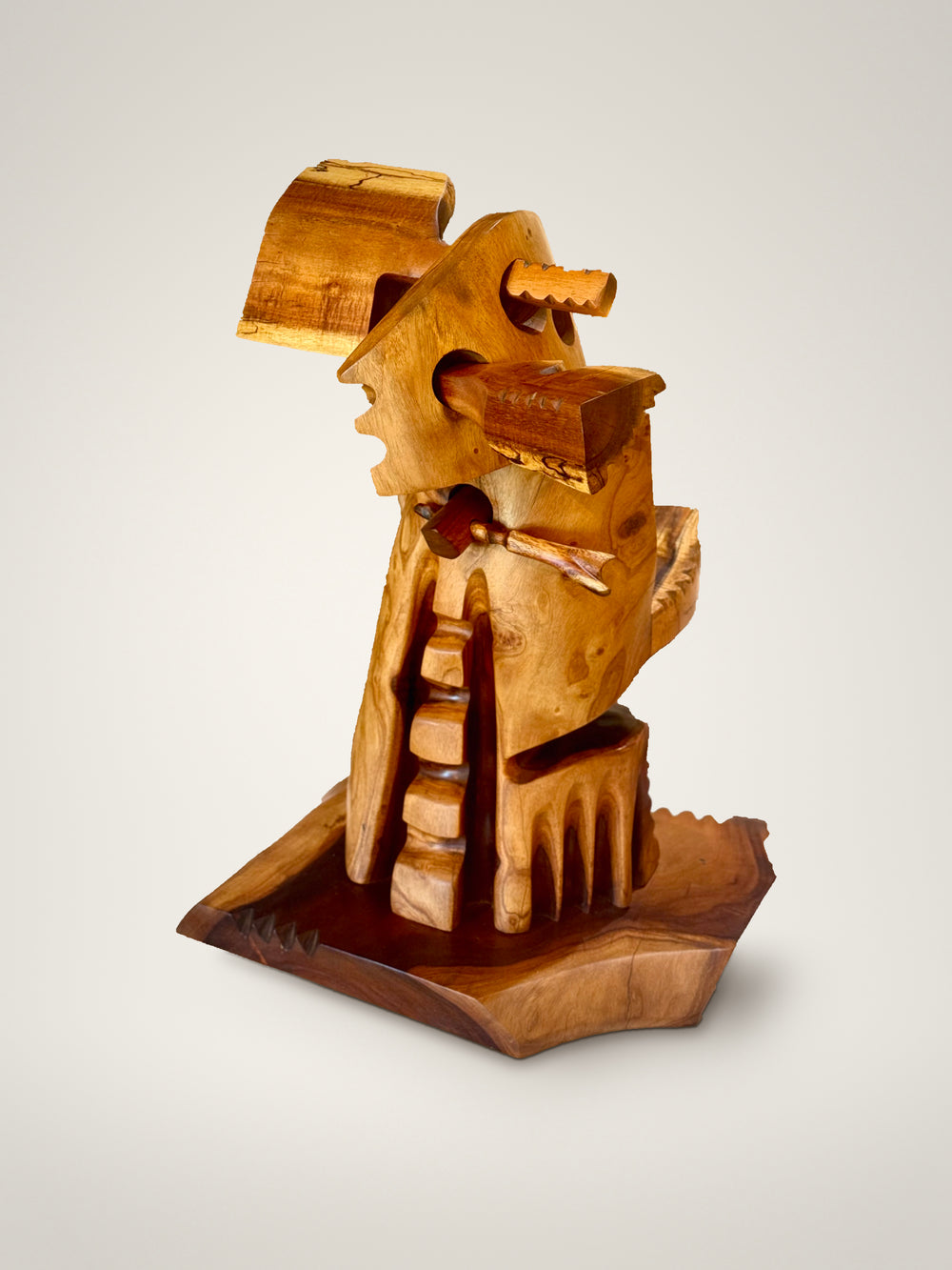 Holomua, Milo and Koa wood sculpture by Avi Molinas: a carved figure carrying a piece of Koa, on a wood base, on a white studio background