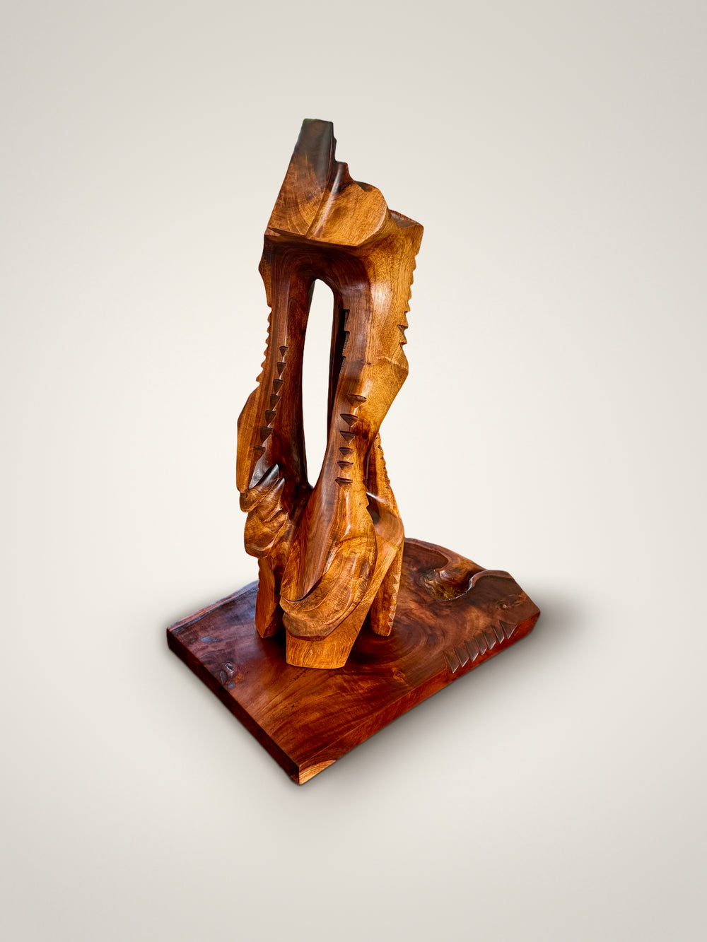 Lawaiʻa | The Fisherman, carved wood sculpture by Avi Molinas: a tall open form with rows of carved notches, on a wood plinth, on a white studio background