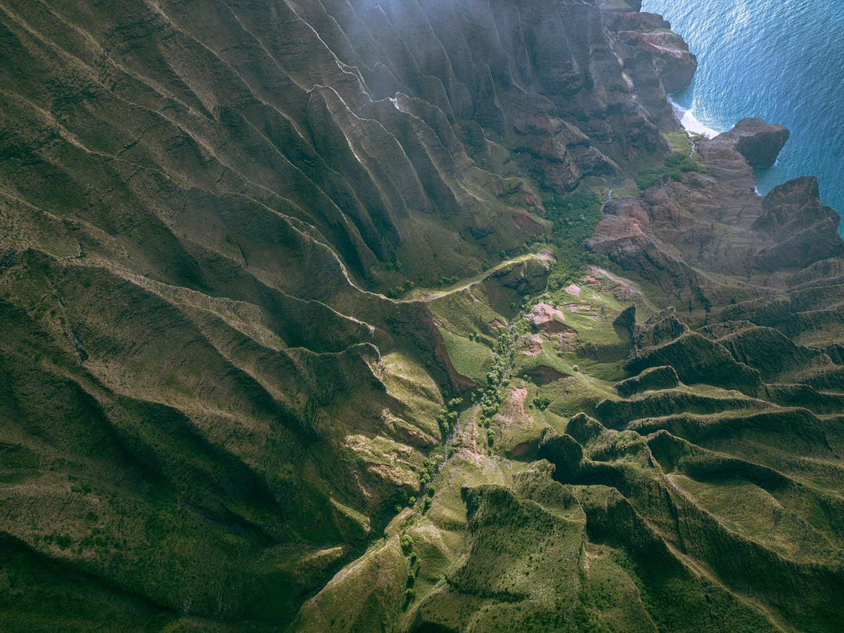 Over the Edge by Lance Ehrecke, aerial photograph above Kauaʻi's Nā Pali Coast near Honopū Beach.